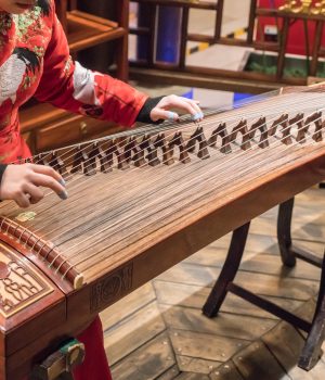 The girl is playing a guqin in a tea house in Chongqing, China.