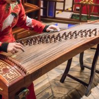 The girl is playing a guqin in a tea house in Chongqing, China.