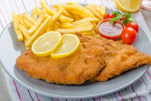 Schnitzel with french fries and a spicy dip, fresh from red orange